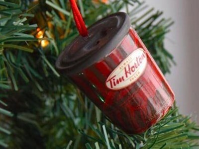A tim horton's coffee cup hanging from a christmas tree.