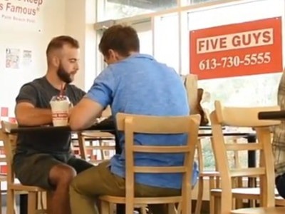 Customers eating inside Five Guys Burger and Fries restaurant.