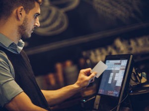 A man is using a credit card at a bar.