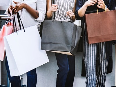 A group of women holding shopping bags.