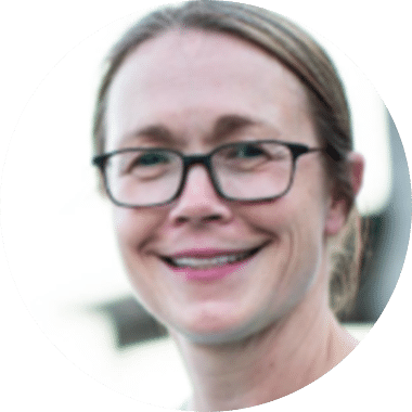A woman with glasses smiling in a circle.