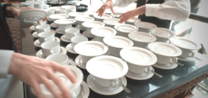 A table full of white cups and saucers.