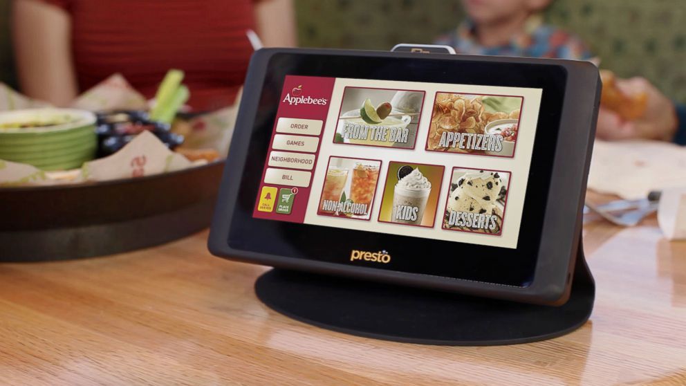 A tablet is sitting on a table in a restaurant.