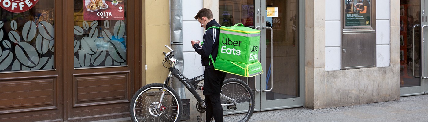 Uber eats bike driver picking up delivery item at a restaurant.