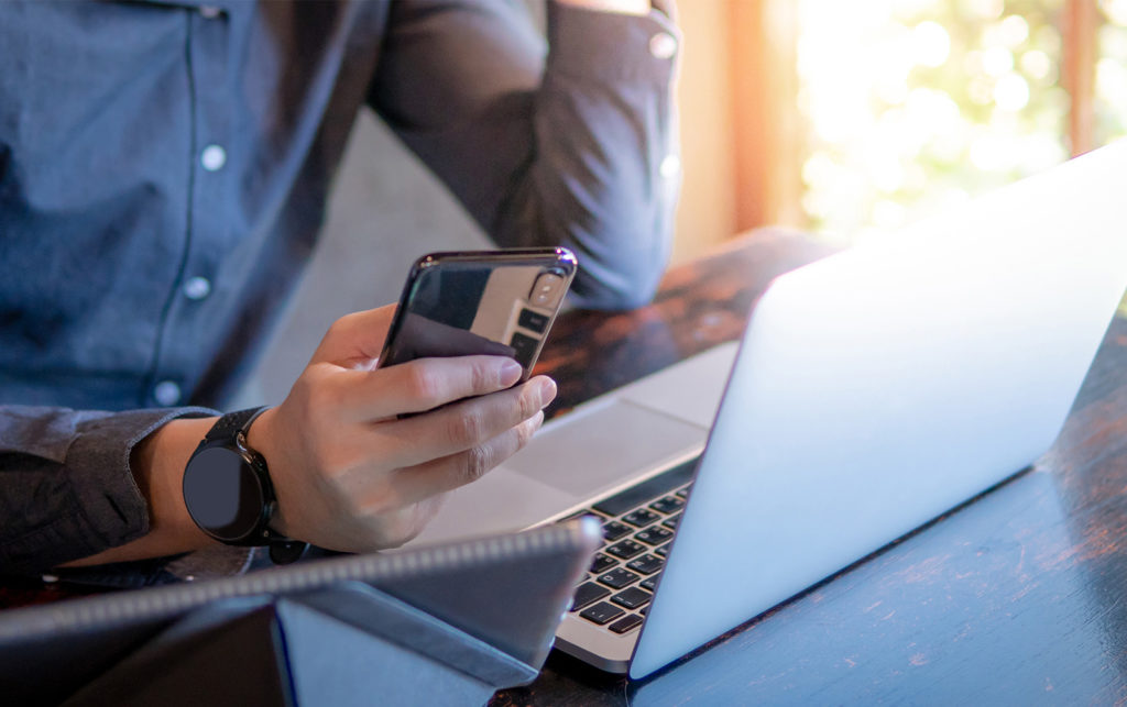 Businessperson on their phone and laptop.