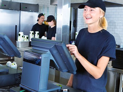 A woman working at a cash register in a restaurant.