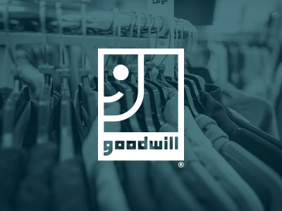 Goodwill logo with clothing in the background.