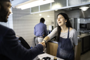 Barista shaking hands with customer
