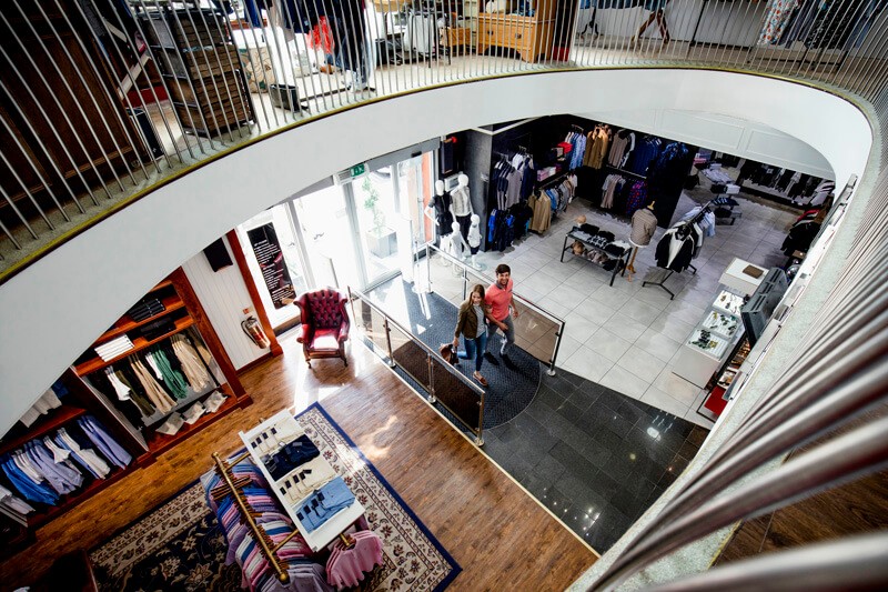 A view from the top of a spiral staircase in a clothing store.