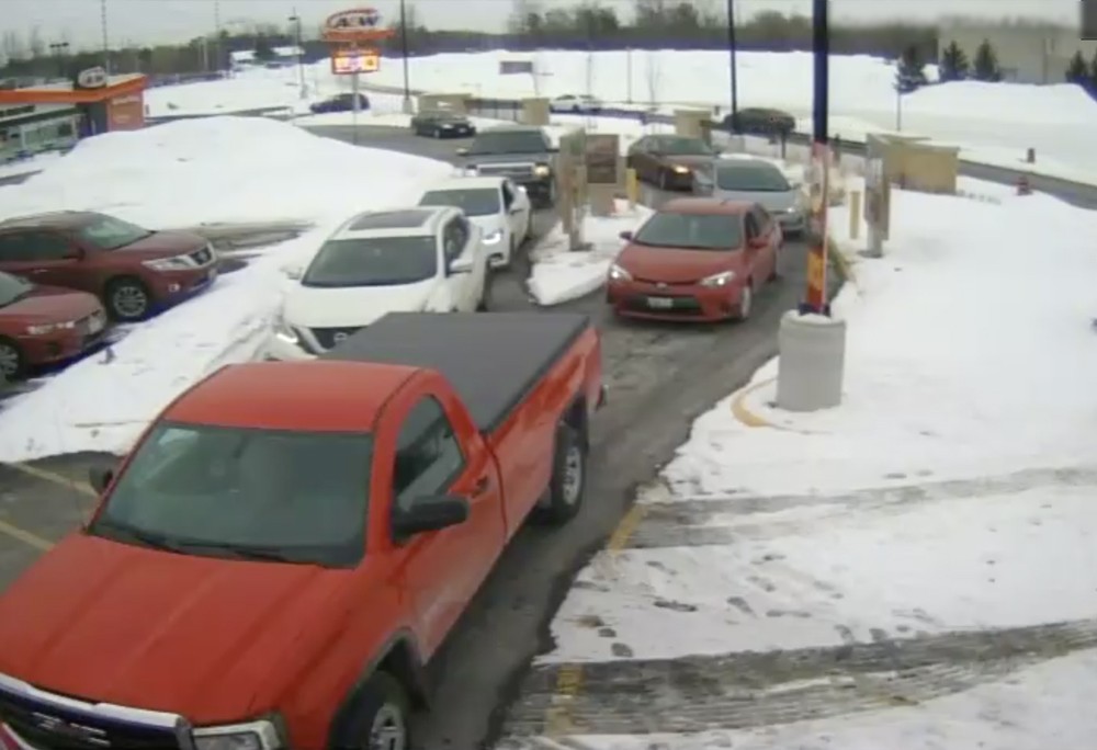 A red pickup truck is parked in a parking lot.