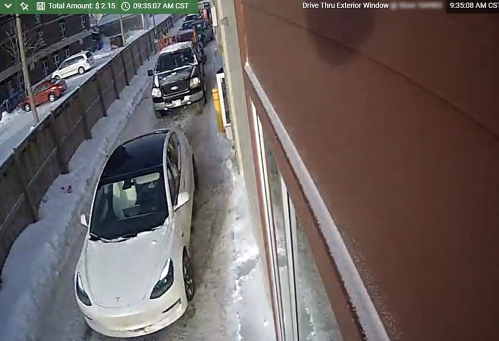 A car is parked in a snowy parking lot.
