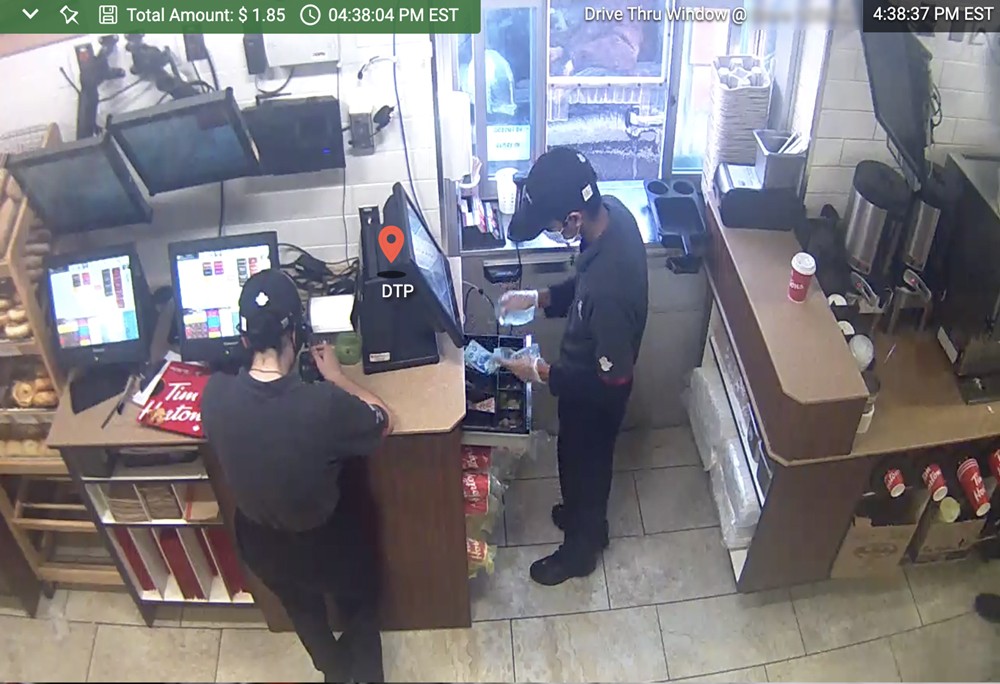 A surveillance video of two men working at a fast food restaurant.