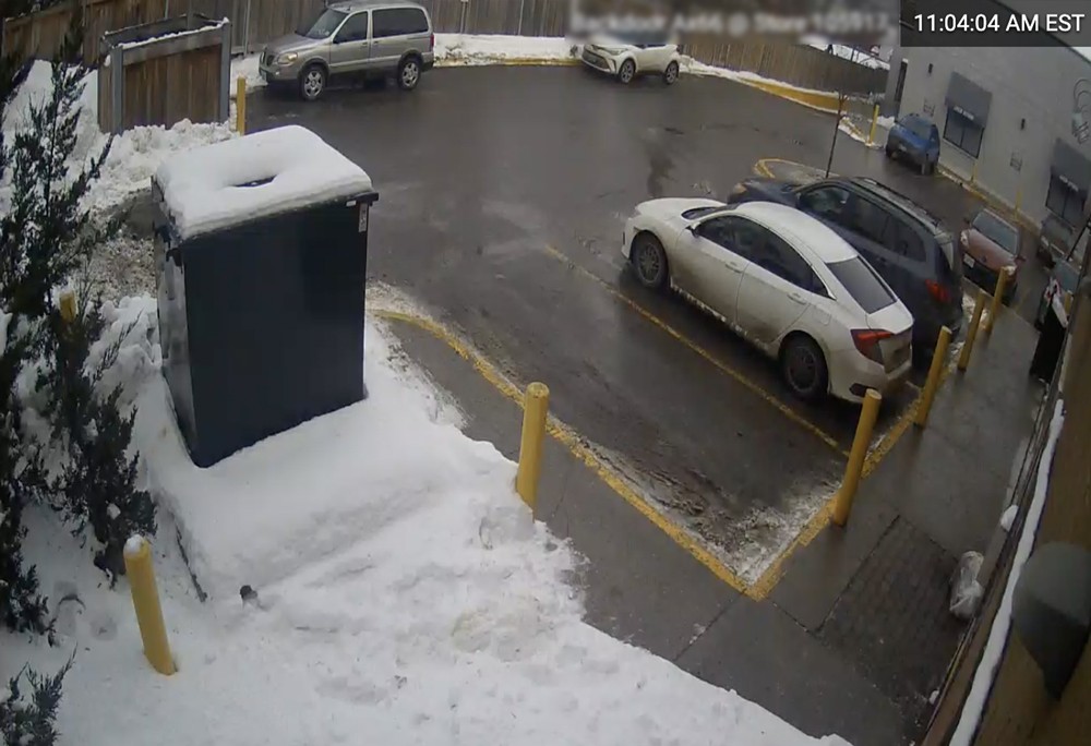 A car is parked in a parking lot with snow on the ground.
