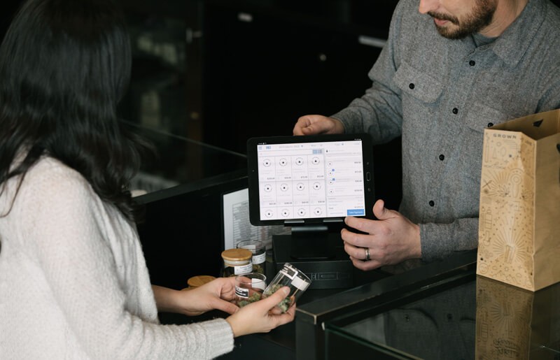 A man and woman standing at a counter with a tablet.