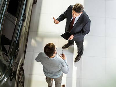 Two men conversing in a car dealership