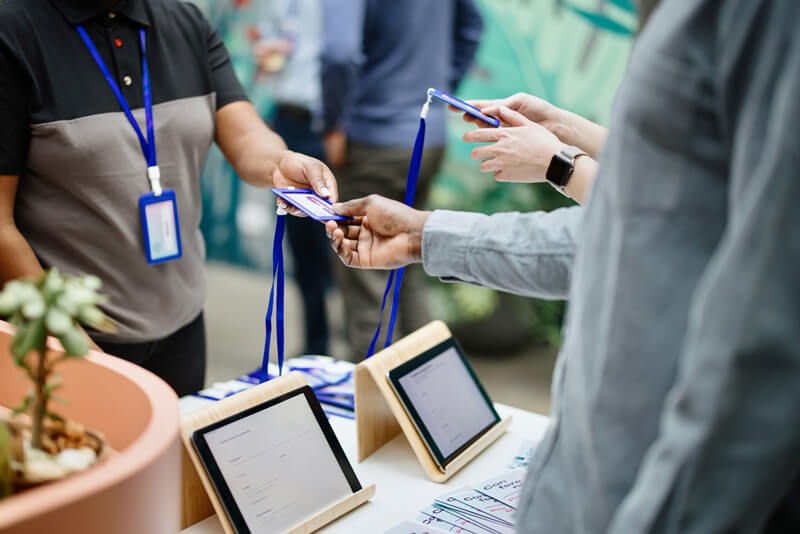 A person handing over a keycard badge at an event or tradeshow