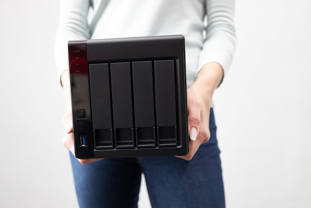 A woman holding a Network Attached Storage device
