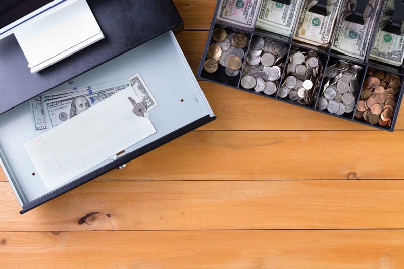 Cash register on a wooden table with the cash tray separated from the drawer