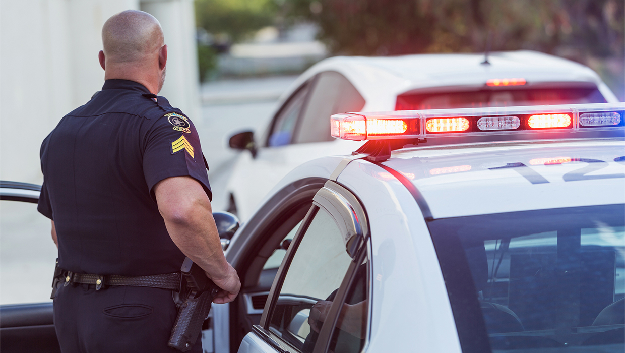 A police officer standing next to a car.