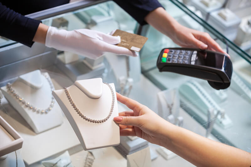 A woman is paying for a necklace in a jewelry store.