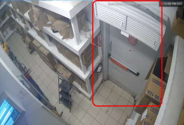 A camera shows a door in a warehouse.