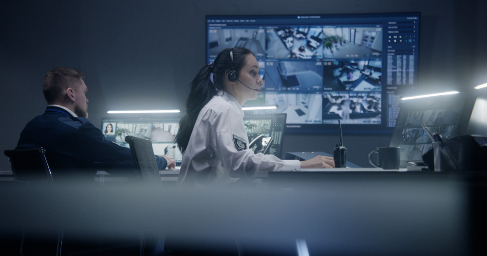 Two people working at a computer in a dark room.