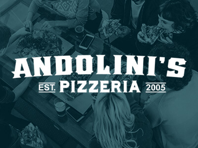 Overhead view of a group of people dining at andolini's pizzeria, established in 2005.
