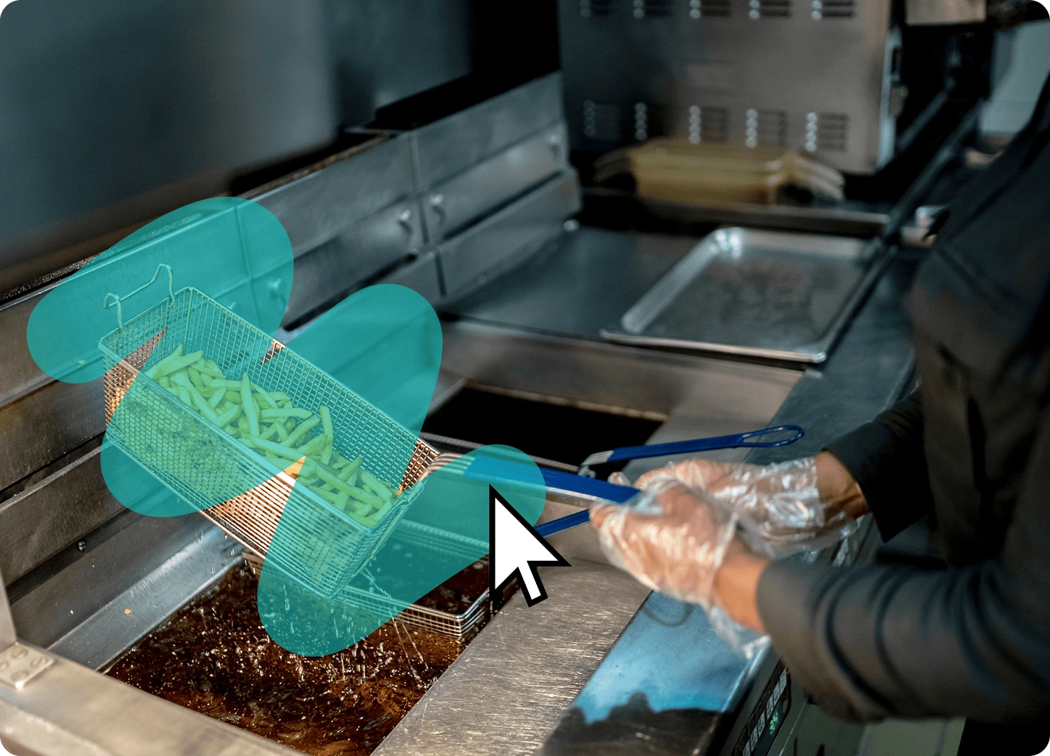 Person lowering a basket of fries into a deep fryer.