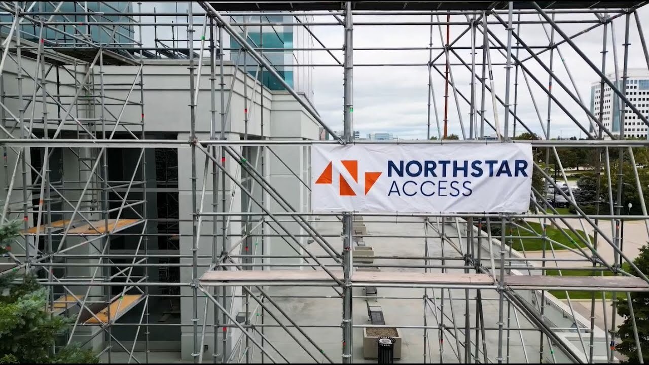 Scaffolding setup with a "Northstar Access" banner attached, positioned near a modern building.