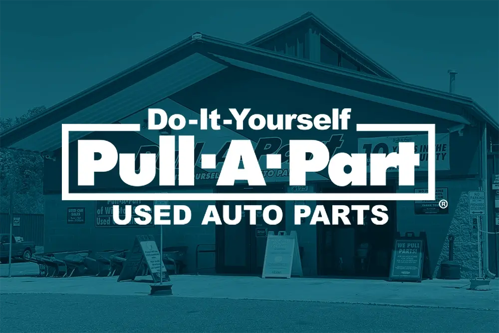 Exterior of Pull-A-Part, a used auto parts store, with a large sign reading "Do-It-Yourself Pull-A-Part Used Auto Parts.