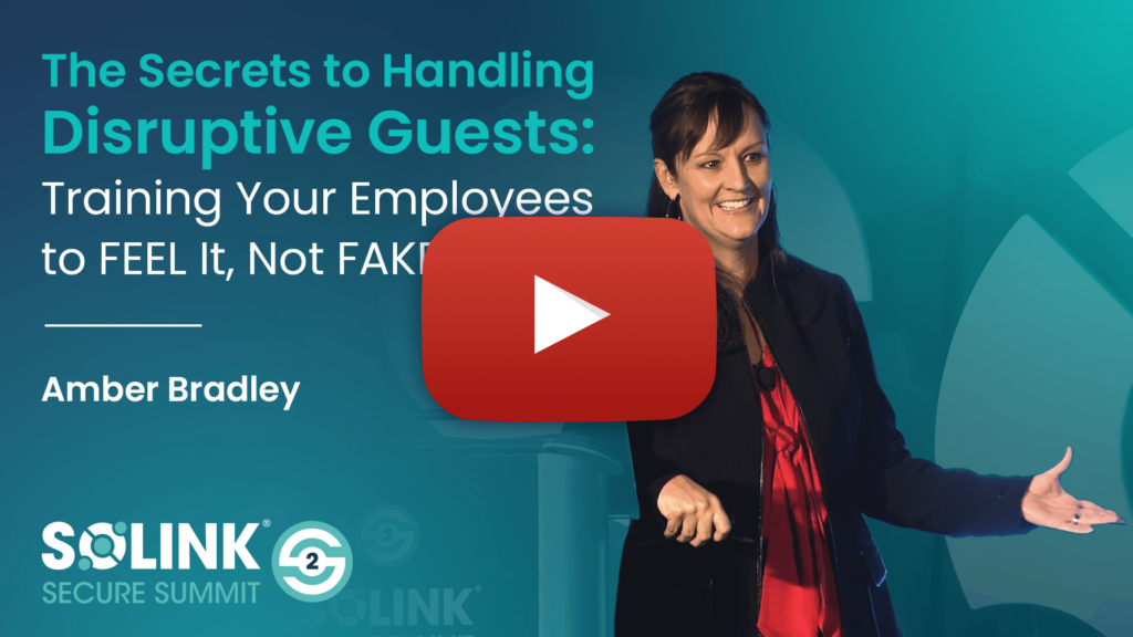 A woman speaks on stage at the Solink Secure Summit with a presentation titled "The Secrets to Handling Disruptive Guests" by Amber Bradley.