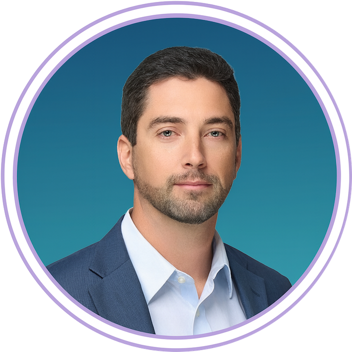 Man with short dark hair and trimmed beard wearing a blue suit jacket and white shirt, posed against a blue background within a circular border.