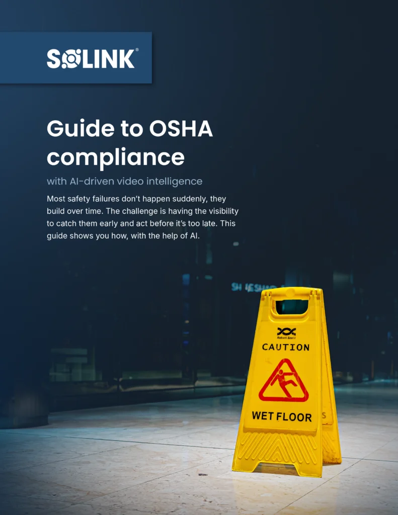 A yellow "Caution Wet Floor" sign stands on a shiny floor; the image features a "Guide to OSHA compliance with AI-driven video intelligence" headline from Solink.